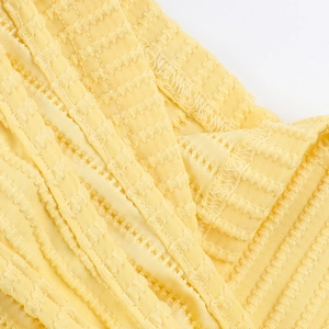Detailed macro view of yellow striped jacquard fabric texture and stitching quality