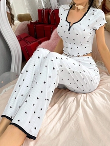 Detail of white pajamas with black heart prints and lace trim on textured fabric
