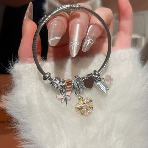 Detail of silver charm bracelet with pink enamel flower and heart pavé pendants