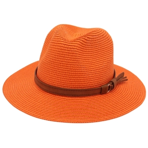 Detail of orange woven straw Fedora hat featuring a brown leather band and metal buckle