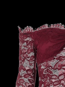 Dettaglio del pizzo floreale rosso vino e del motivo traforato sulla spalla