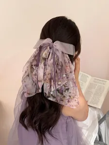 Dettaglio molletta per capelli in chiffon floreale viola con nastri lunghi e ciondoli