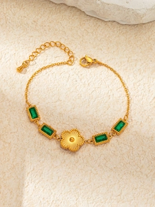 Detail of gold vintage bracelet featuring emerald-green zircons and radial floral center