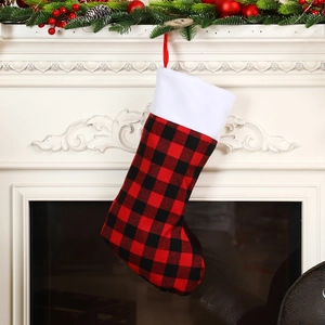 Classic red and black buffalo plaid Christmas stocking with plush trim on a white mantel