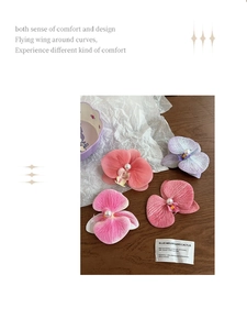 Detail of orchid hair clips set with realistic fabric petals and white pearl centers