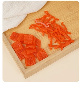 Vista detallada de rodajas de pimiento rojo de PVC en una bandeja de bambú para decoración