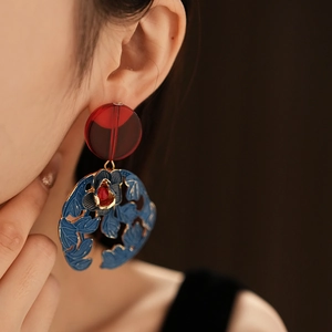 Close-up of vintage floral earrings with red resin and blue hollowed petals