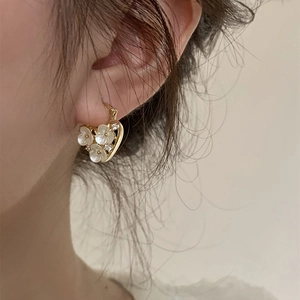18k gold plated heart hoop earrings with white flowers and zircon stones on earlobe