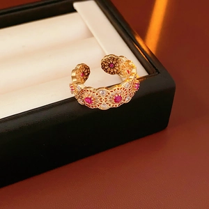 Macro di anello aperto placcato oro 18k con gemma rossa e dettagli in filigrana