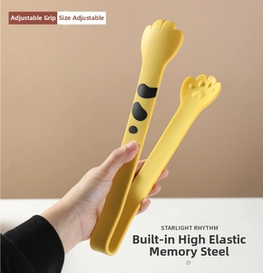Close-up of yellow cat paw food tongs showing adjustable opening and flexible steel core