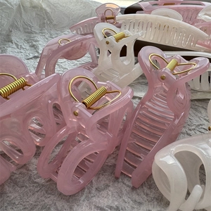 Close-up of jelly pink and white hair claws with gold springs on paper background