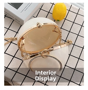 Macro shot of white spherical evening bag interior with gold trim and diamond handle