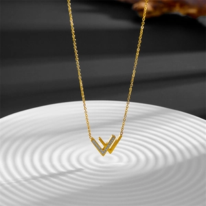 Detail of gold double V pendant with cubic zirconia stones and polished finish