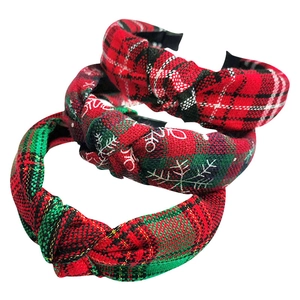 Detail of red and green plaid knotted headbands with snowflake patterns in fabric textures