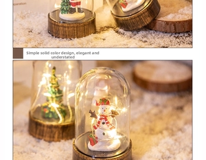 Detail of Santa and Snowman LED glass dome lantern with warm lighting and wooden base