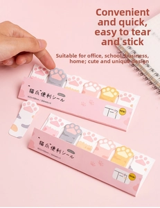 Close-up of hand peeling a cute pink cat paw sticky note index tab for planners