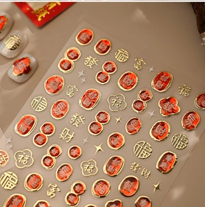 Detail of red and gold embossed 3D nail stickers with traditional Chinese fortune symbols