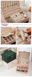 Detail of the multi-layer leather jewelry box featuring a golden lock and partitioned storage