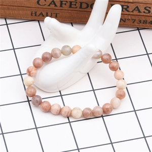 Detail of 8mm natural stone beaded bracelet on white ceramic hand display stand