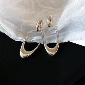 Macro shot of silver geometric hollow oval earrings with high-polish mirror finish