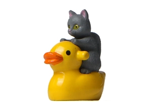 Detailed side view of a gray resin cat figurine riding a bright yellow rubber ducky