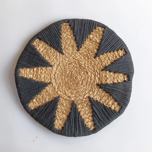 Bohemian round straw wall decor with natural fibers and black geometric triangle patterns