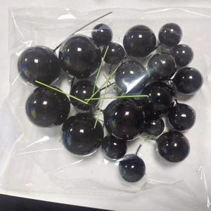 Detail of 20pcs glossy black foam balls with green stems for cake decoration in polybag