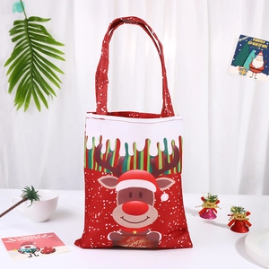 Detail of red Christmas canvas gift bag with cartoon reindeer print and festive decorations