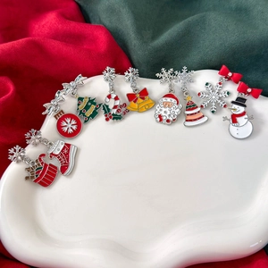Weihnachtliche Ohrringe Kollektion mit bunten Emaille Anhängern auf einer weißen Ablage