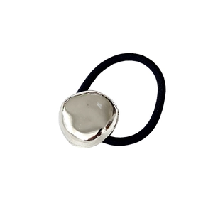 Détail de l'élastique à cheveux minimaliste avec breloque en alliage argenté et cordon noir