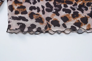 Detail of lettuce hem stitching on a leopard print mesh fabric garment for women