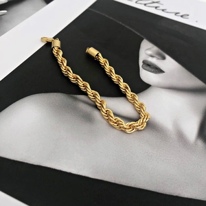 Close-up of golden stainless steel twist rope chain bracelet on a stylish magazine