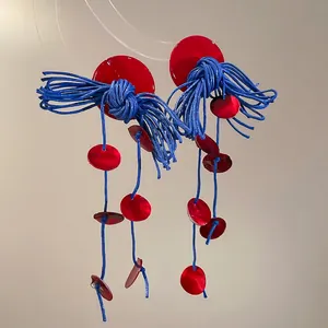 Artistic shell tassel earrings with red circular plates and blue woven cord tassels