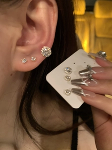 Detailed view of silver-plated round zircon stud earrings set in various sizes