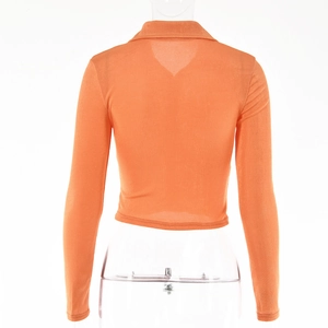 Detail of orange ribbed crop top showing back V-shaped neckline and fabric texture