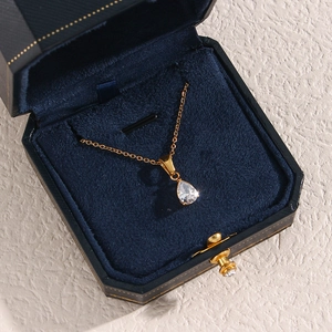 Détail du collier avec pendentif goutte en zircon et or 18K dans un écrin en velours bleu