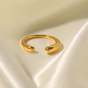 Detail of 18K gold-plated open ring with smooth water drop ends on silk background