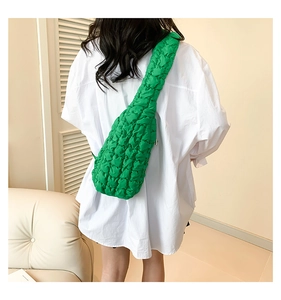 Sac nuage vert à texture bulle porté en bandoulière sur une tenue blanche