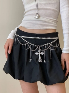 Détail de chaîne de taille à perles superposées avec pendentifs croix en strass argent