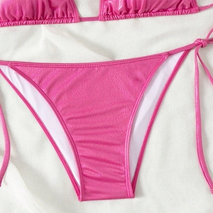 Glittery rose pink lace-up bikini bottom with metallic sheen on white silk background