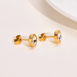 Detailed macro view of gold-plated titanium earrings with sparkling clear cubic zirconia
