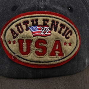 Detailed close-up of retro USA patch embroidery on a vintage washed cotton baseball cap