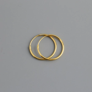 Detail view of smooth 925 silver hoop earrings with a minimalist golden polished finish