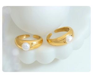 Detail of two adjustable gold rings featuring elegant white freshwater pearls on white background