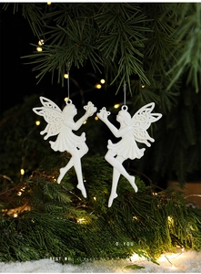 Close-up of white glittery fairy ornament hanging on a Christmas tree branch