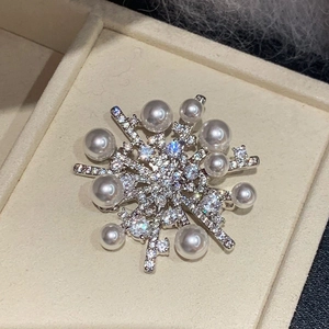Elegant snowflake brooch with micro-pave zircons and white pearls in silver base