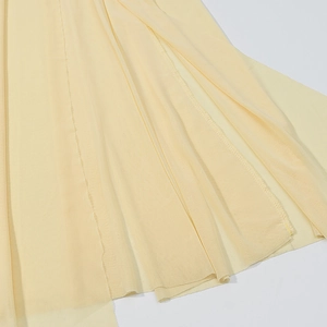 Détail du tissu en maille transparente jaune clair avec couture fine et texture superposée