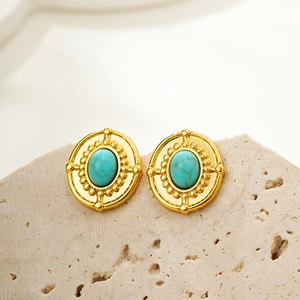 Macro shot of vintage oval turquoise earrings with 18K gold embossed detailing on rock