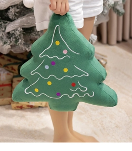 Close-up of soft green Christmas tree plush pillow with colorful embroidered dots