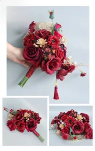 Detail of red bridal bouquet with golden fan leaves, crimson roses and silk tassels
